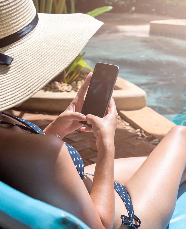 woman on phone by the pool