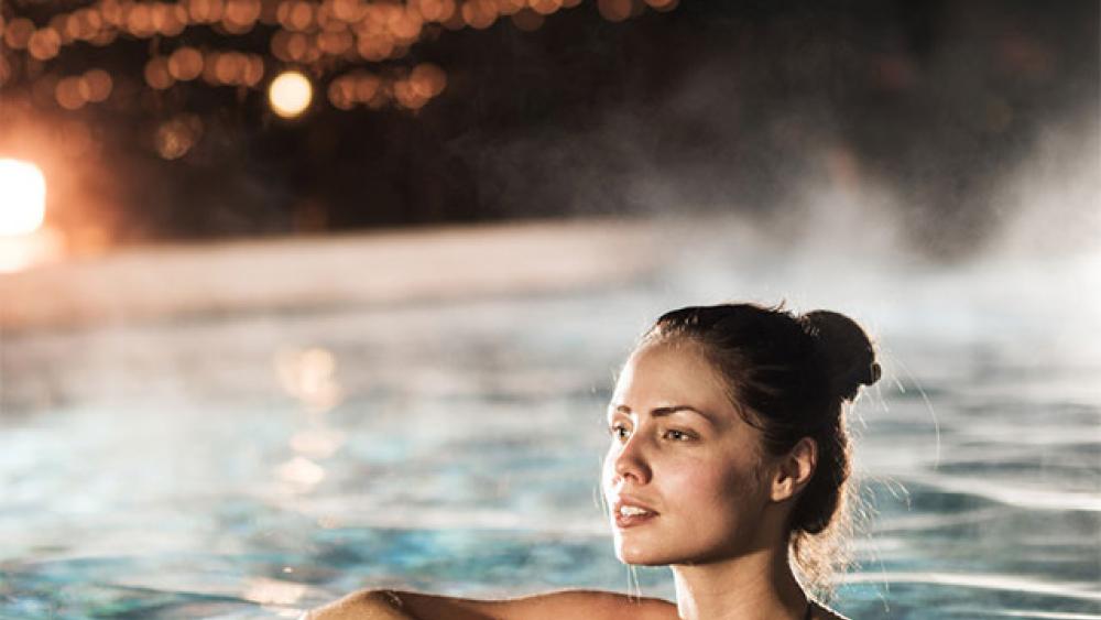 femme qui se baigne le soir dans une piscine chauffée